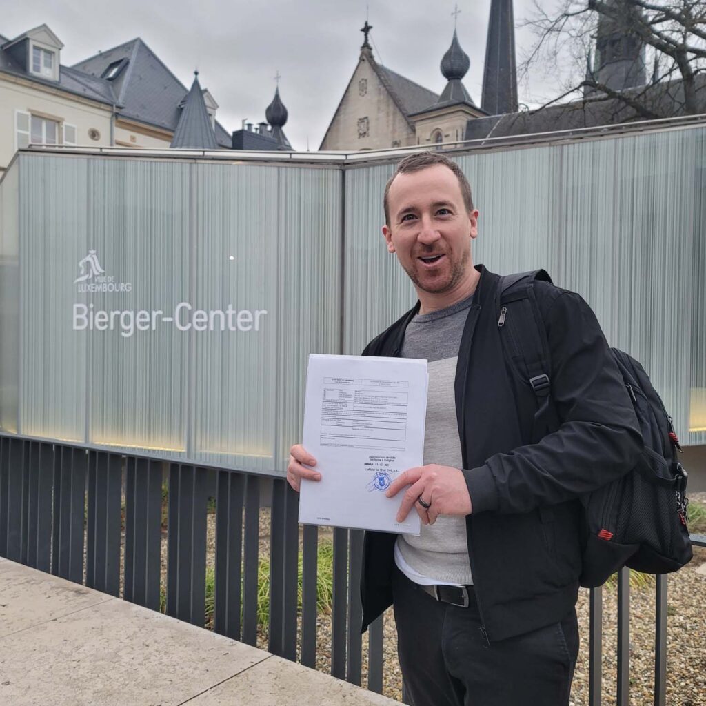 LuxCitizenship client holding his signed Luxembourg citizenship declaration outside the Bierger-Center in Luxembourg City