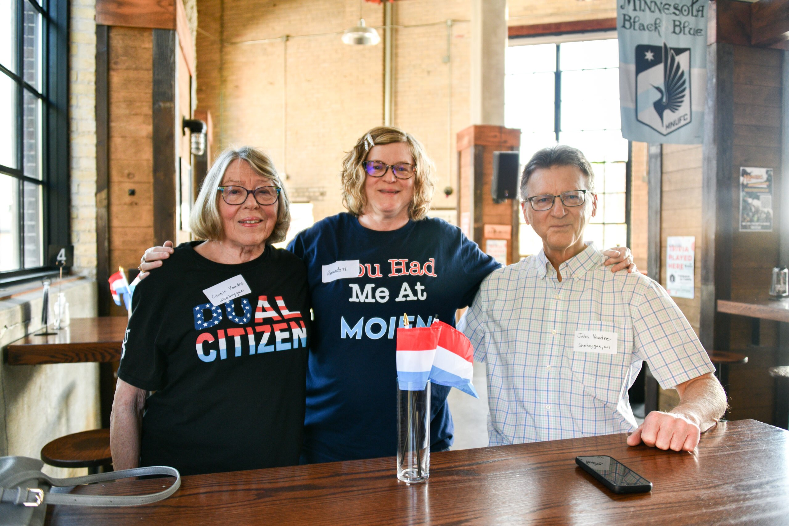 Three adults in a Minnesota bar at a Luxembourg ancestor meetup.