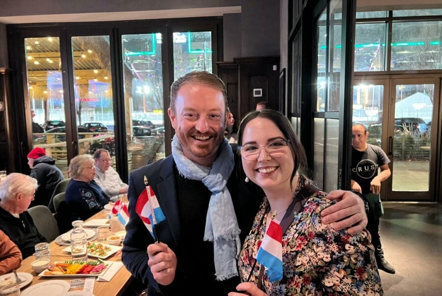 Two people holding Luxembourg flags