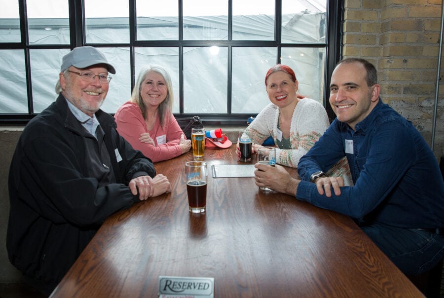 Four people in a brew pub sitting at a table
