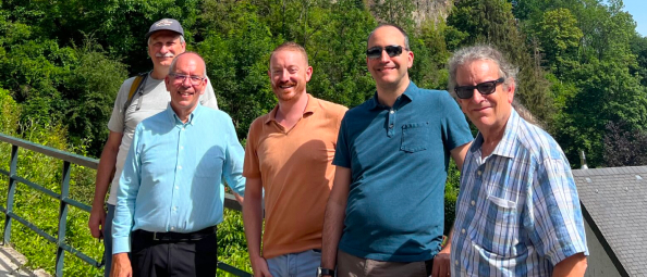 Group of men standing in Luxembourg City with a tree-filled background