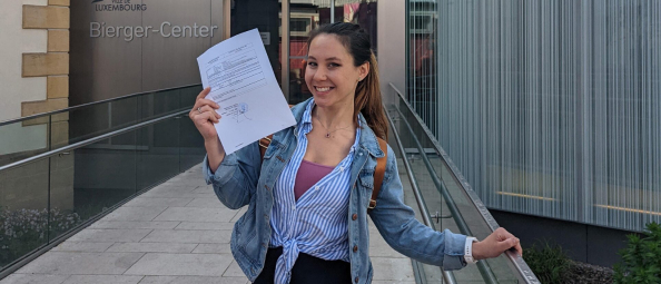 Woman with Luxembourg dual citizenship official paperwork outside of the government building