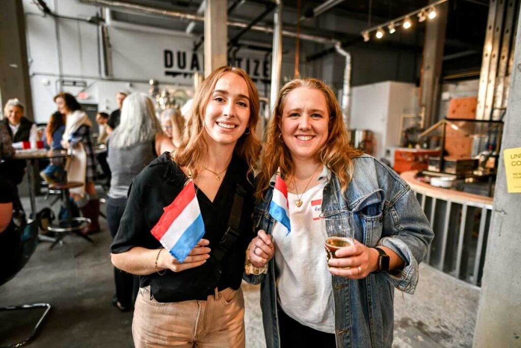 Two Luxembourger dual citizens holding flags