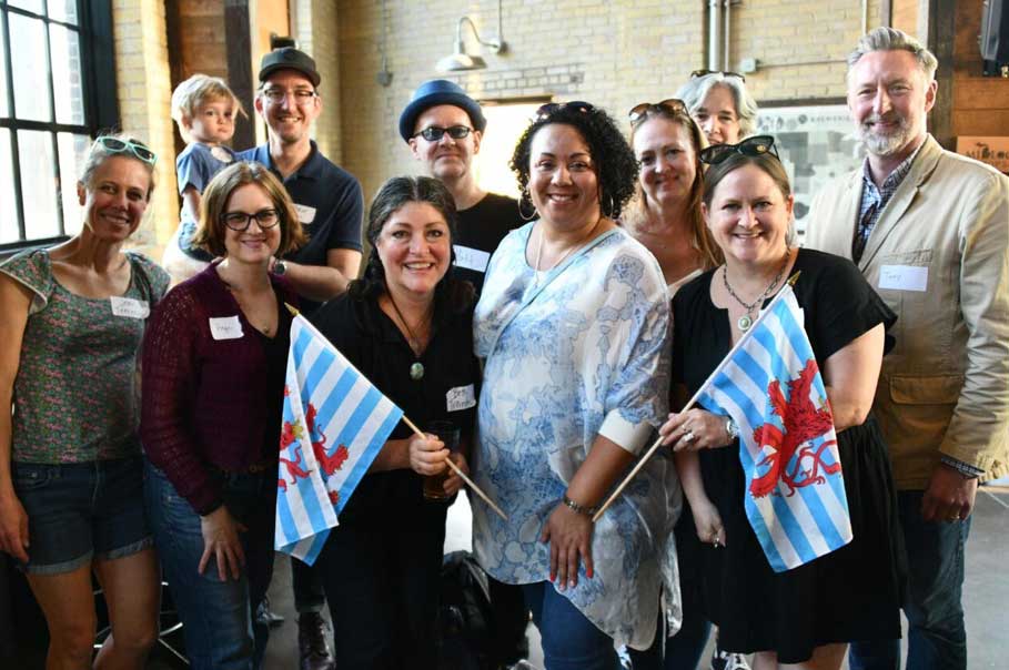 Group of people in a brewery holding Luxembourg flags