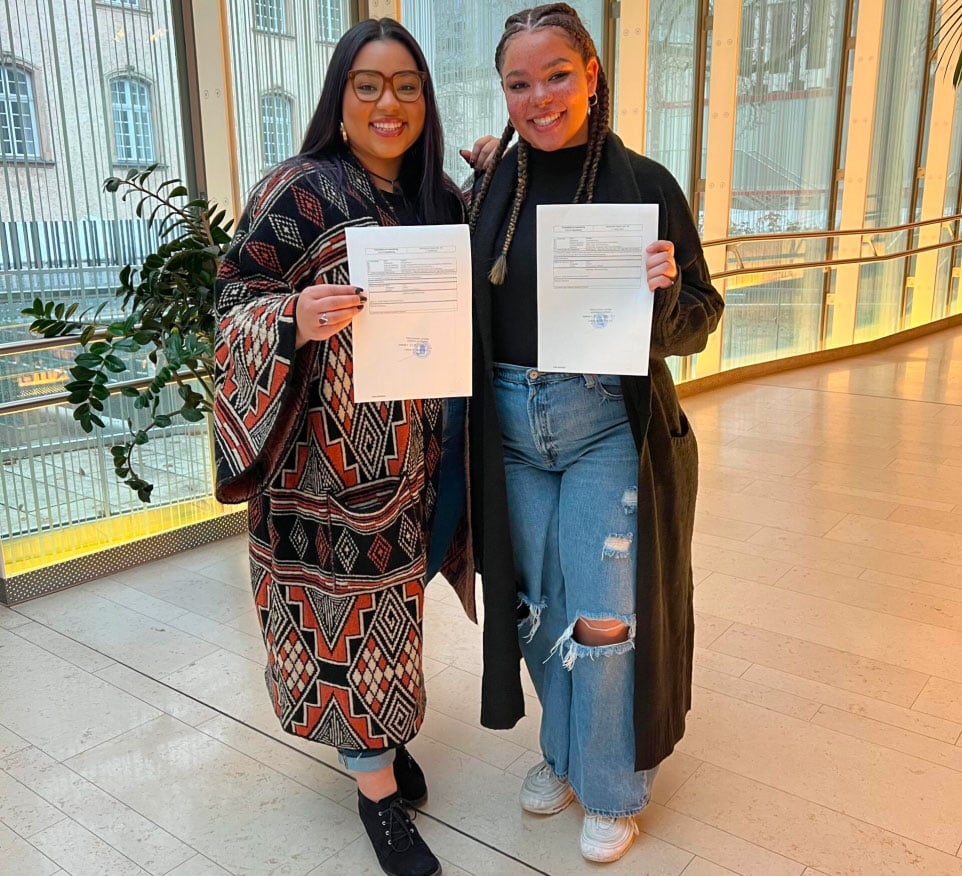 Two dual citizens in Luxembourg holding their citizenship paperwork.
