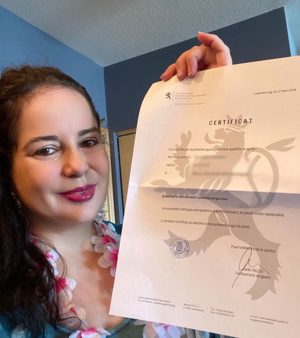 Smiling dual citizen of Luxembourg holding their certificate.