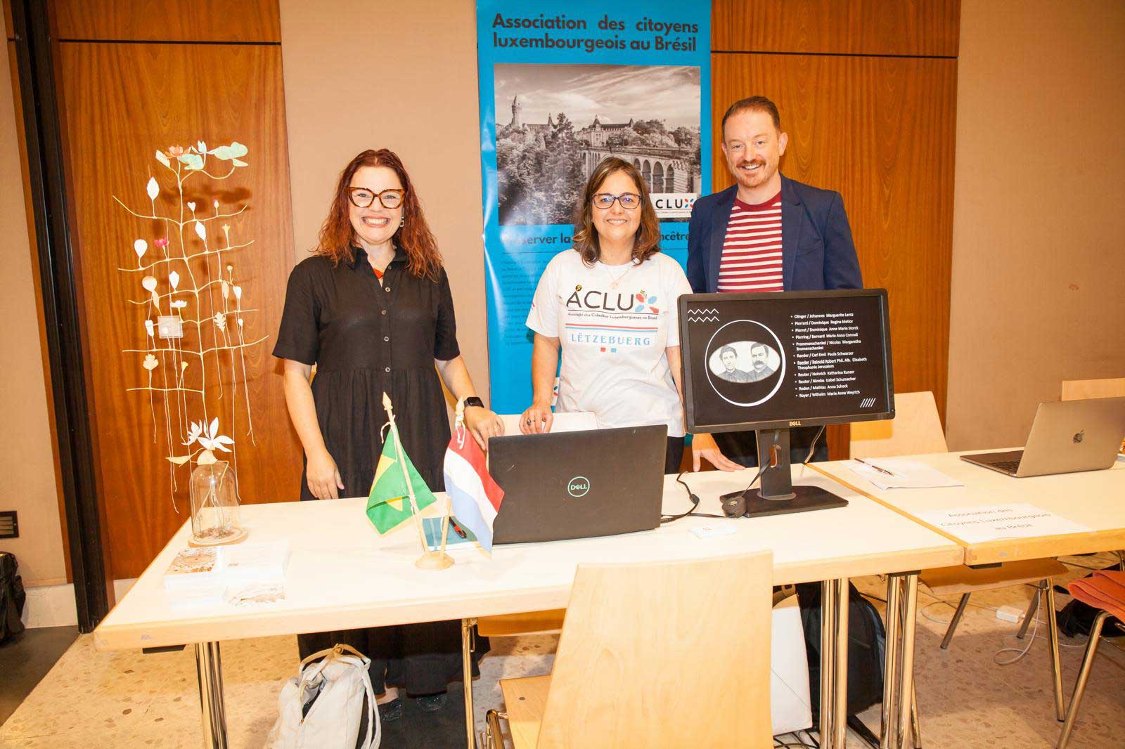 Daniel Atz and two others at a table presenting for National Day of Culture and Heritage.