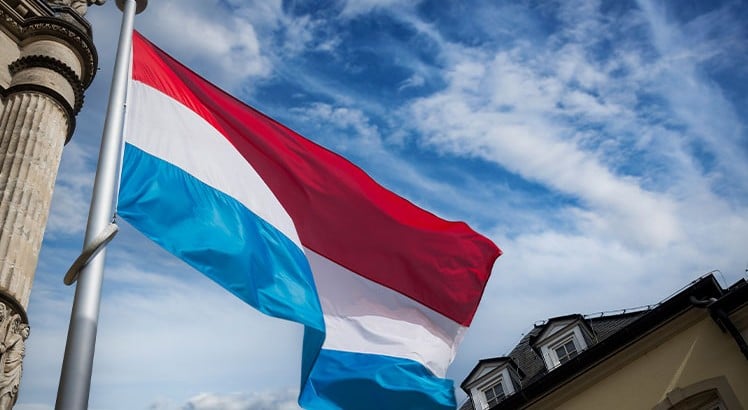 Flag of Luxembourg flying against a blue sky